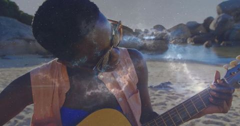 Musician Playing Guitar on Beach Under Starry Sky