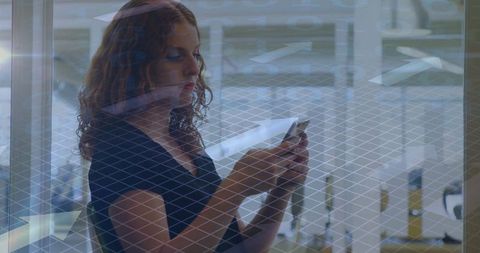 Woman analyzing smartphone through geometric glass barrier