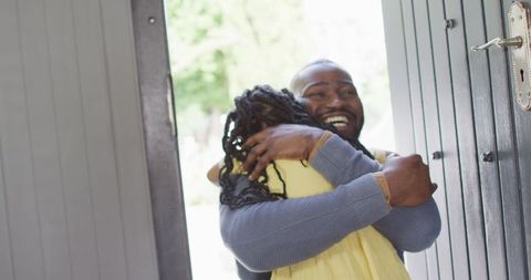 Joyful Reunion: Father and Daughter Embracing at Front Door