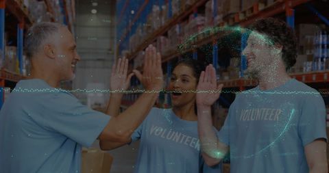 Diverse volunteers celebrating in storage area with digital data overlay