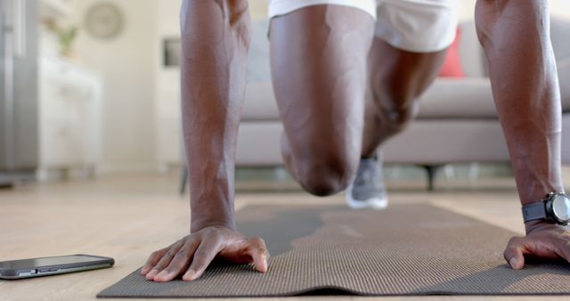 Man doing indoor workout with smartphone on exercise mat - Download Free Stock Images Pikwizard.com