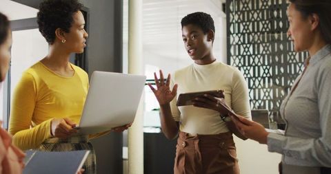 Diverse Businesswomen Collaborating with Technology in Office