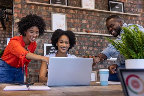 Modern Office Team Collaborating Around Laptop