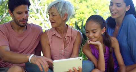 Diverse Family Sharing Digital Tablet Experience Outdoors