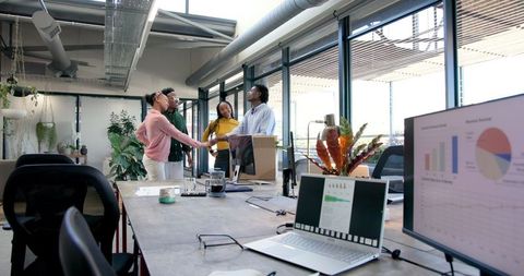 Diverse Team Celebrates Success with Cheerful High-Fives in Modern Office
