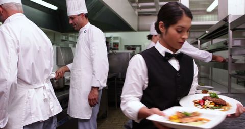 Busy Restaurant Kitchen with Waitress Carrying Food Orders - Download Free Stock Images Pikwizard.com