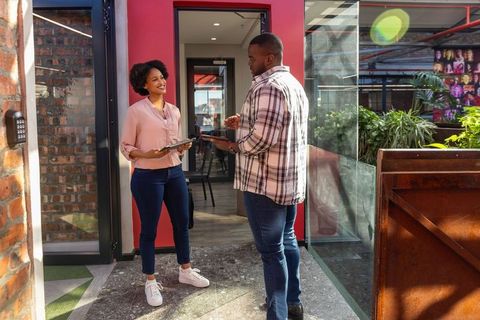 Coworking professionals discussing project with tablets in modern workplace