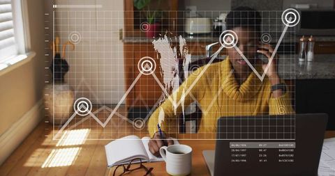 Talking on phone while taking notes with laptop and analytics overlay for home office
