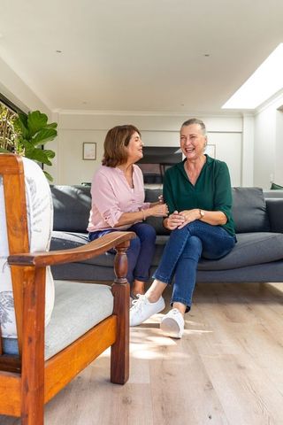 Senior women enjoying warm friendship in cozy living room