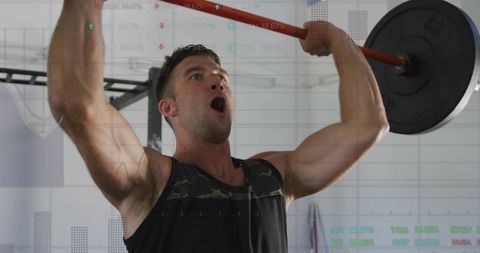 Male Athlete Performing Overhead Barbell Press in Gym Demonstrating Strength and Power