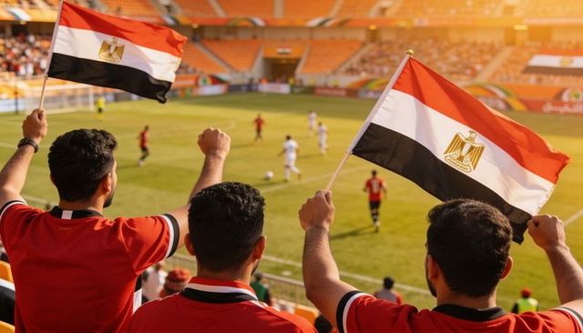 Egyptian football fans waving national flags and cheering team at sunny open-air stadium