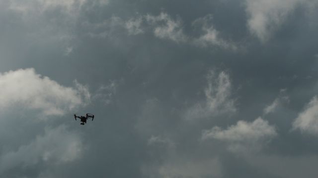 Drone soaring in cloudy sky, suitable for depicting modern technology usage in various weather conditions. Ideal for digital marketing, tech discussions, and atmospheric outdoor scenes.