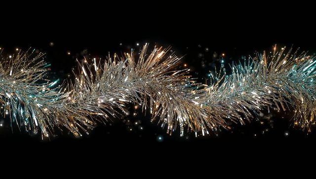 Sinuous Iridescent Tinsel Garland on Black Background with Silver Gold Teal Sparkle