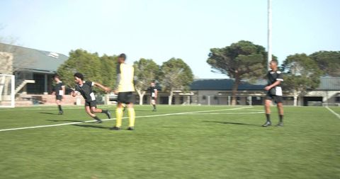 Soccer Players Training on Sunlit Field for Upcoming Match