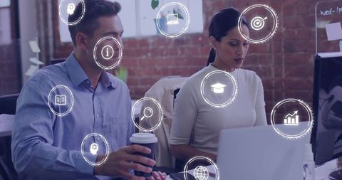 Collaborating professionals at shared desk using laptop with floating data analytics icons