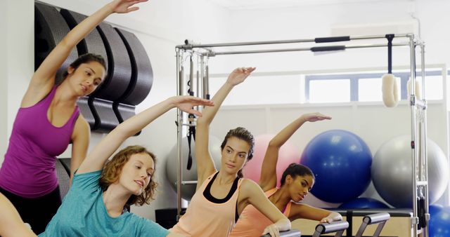 Women Practicing Pilates with Equipment in Fitness Studio - Download Free Stock Images Pikwizard.com