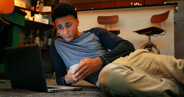 Youthful Man Relaxing While Using Laptop and Smartphone at Home - Download Free Stock Images Pikwizard.com