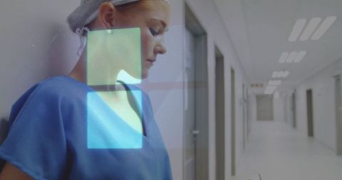 Healthcare Professional Viewing Digital Interface in Hospital Corridor