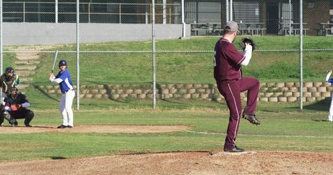 Baseball pitcher mid motion on mound under clear skies