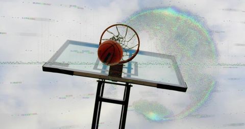 Basketball passing through outdoor hoop with digital glitch and cloudy sky