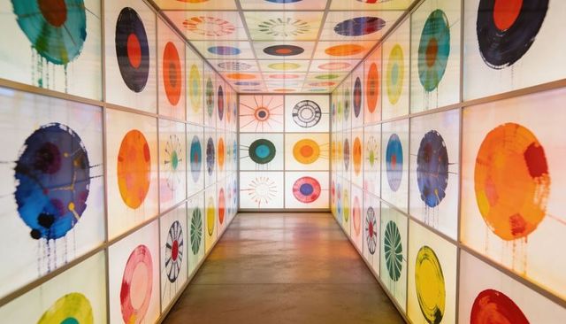 Illuminated Circular Gallery Corridor with Backlit Panels and Vibrant Geometric Art