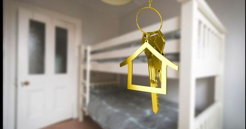 Golden house keychain hanging in modern cozy bedroom