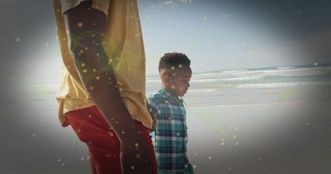 Father and Son Walking on Sandy Beach Under Clear Blue Sky