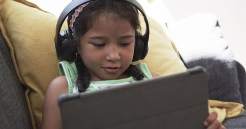 Young Girl Relaxed Digital Learning With Tablet And Headphones