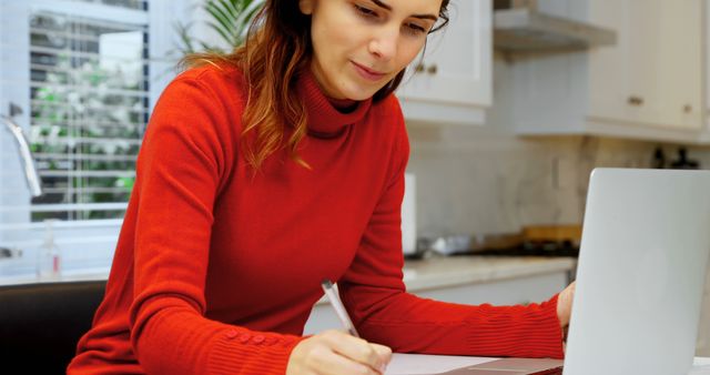 Woman in Red Sweater Working on Laptop at Kitchen Table - Download Free Stock Images Pikwizard.com