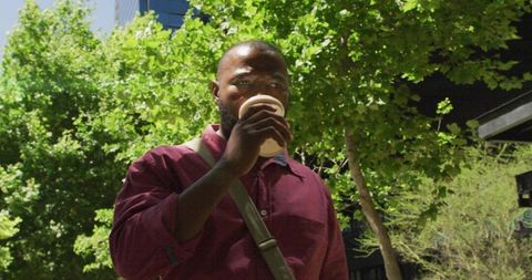 Urban Professional Drinking Coffee Outdoors Amidst Greenery