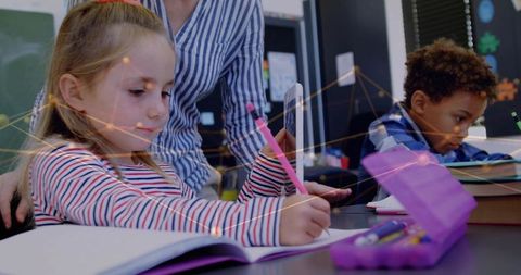 Teacher Assisting Young Students in Classroom for Effective Learning