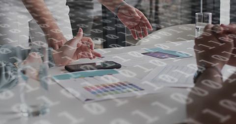 Binary Code Overlay on Business Team Discussing Market Strategy