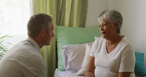 Doctor Discussing Health with Senior Woman in Bedroom