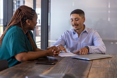 Coworkers Collaborating on Office Document at Wooden Table