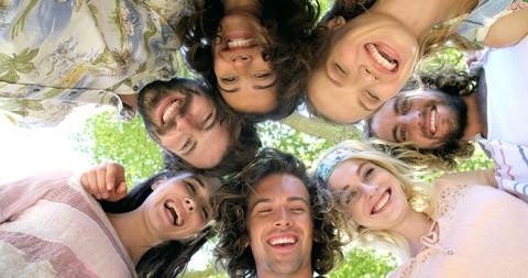Diverse Friends Laughing in a Circle with Sunny Joyful Expressions