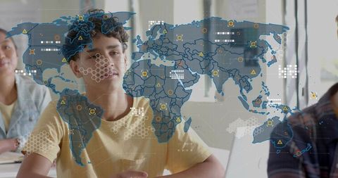 Teenage student studying with interactive world map overlay on laptop in classroom
