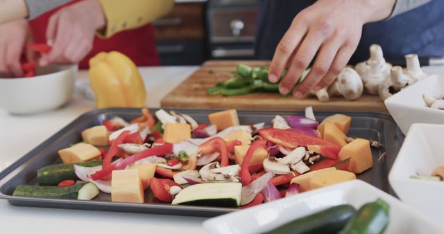 Happy caucasian lesbian couple preparing food and using tablet in sunny kitchen. Togetherness, relationship, domestic life and cooking,communication,unaltered.