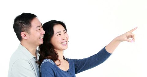 Joyful asian couple sharing happy moment with copy space