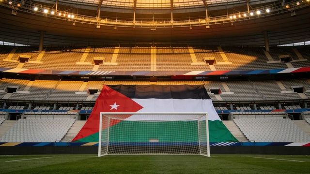 Sunlighting soccer goal draping giant jordan flag behind net in empty stadium