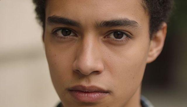 Intense young male close-up headshot emphasizing direct gaze and natural skin texture