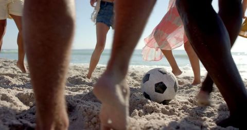Group of Friends Playing Soccer on Beach in Sunlight