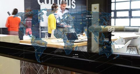 Global team collaborating around table with digital world map overlay and modern workspace