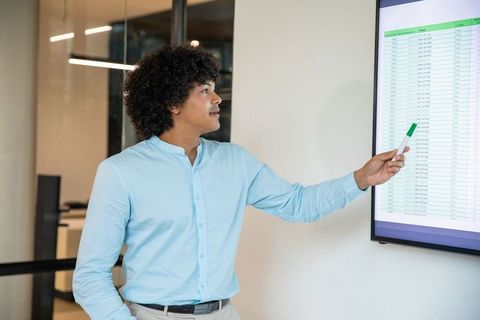 Professional presenting spreadsheet data on office display