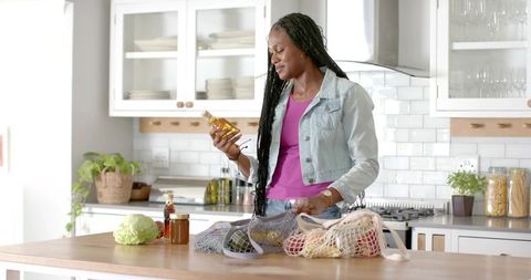 Woman embracing sustainable lifestyle in minimalist kitchen