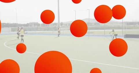 Female field hockey players training on artificial turf near goal with red dot overlay