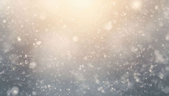 Golden bokeh and sparkling dust floating in soft sunrise light for festive background