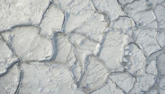Cracked salt flat mosaic featuring polygonal dry plates, brittle crust, mineral fissures