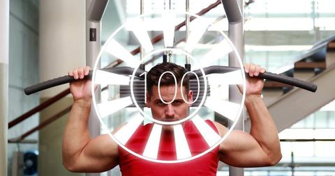 Strong Muscular Man Focused on Lat Pulldown at Modern Gym