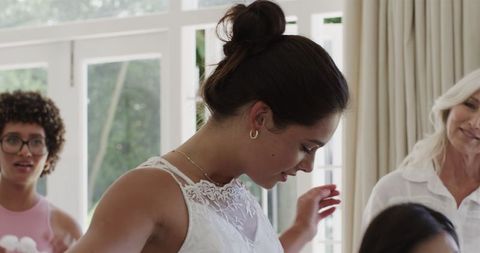 Bride Preparing for Wedding With Assistance of Asian Woman