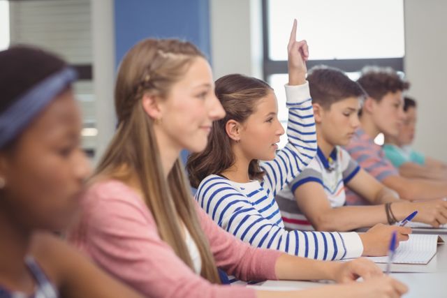 Student raising hand in classroom at school